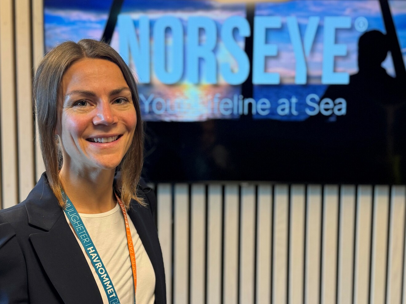 Elina Bjerkestrand synes i forgrunnen, i bakgrunnen sees en skjerm med påskriften 
