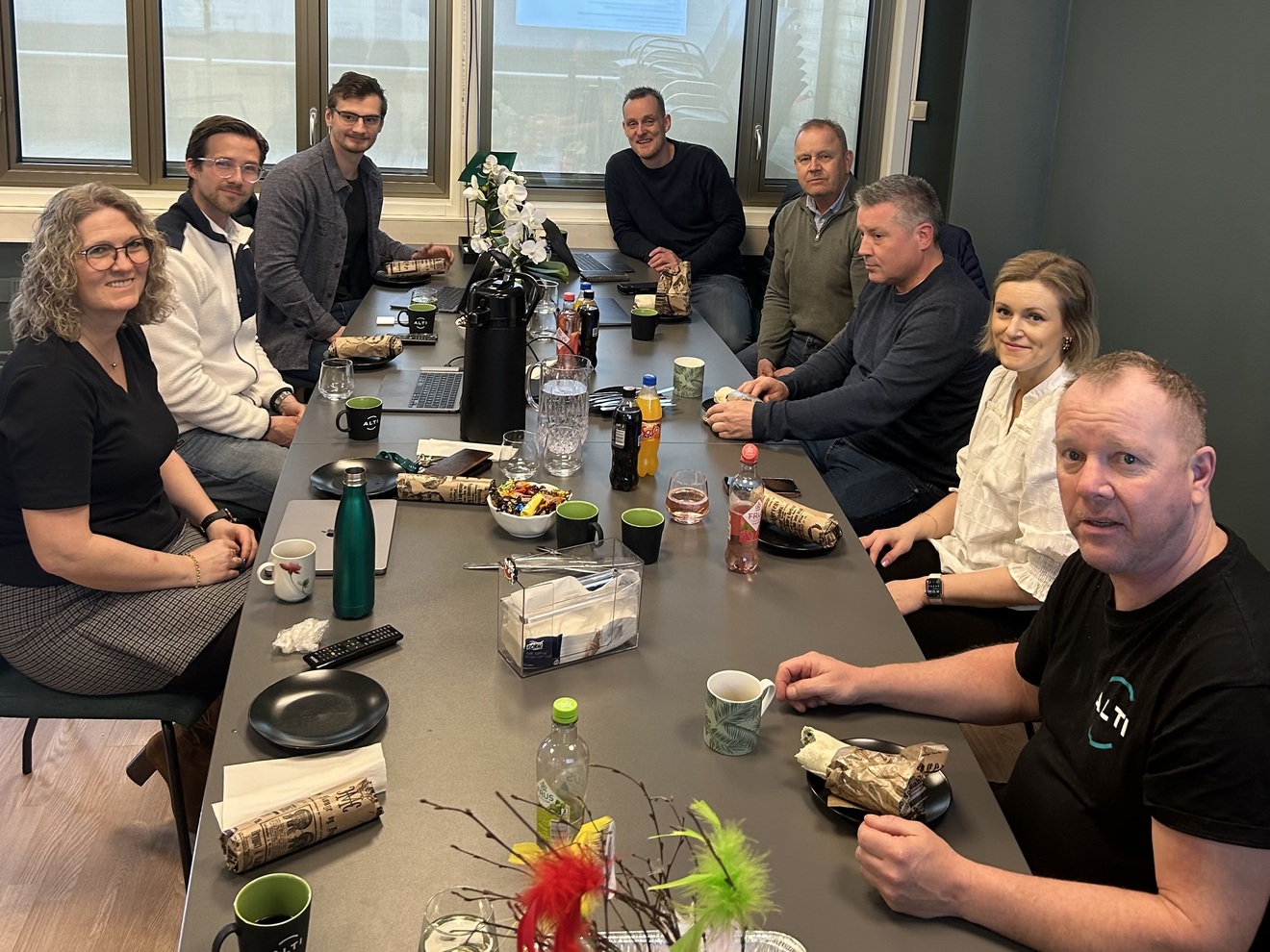 Mange mennesker sitter rundt et bord. 